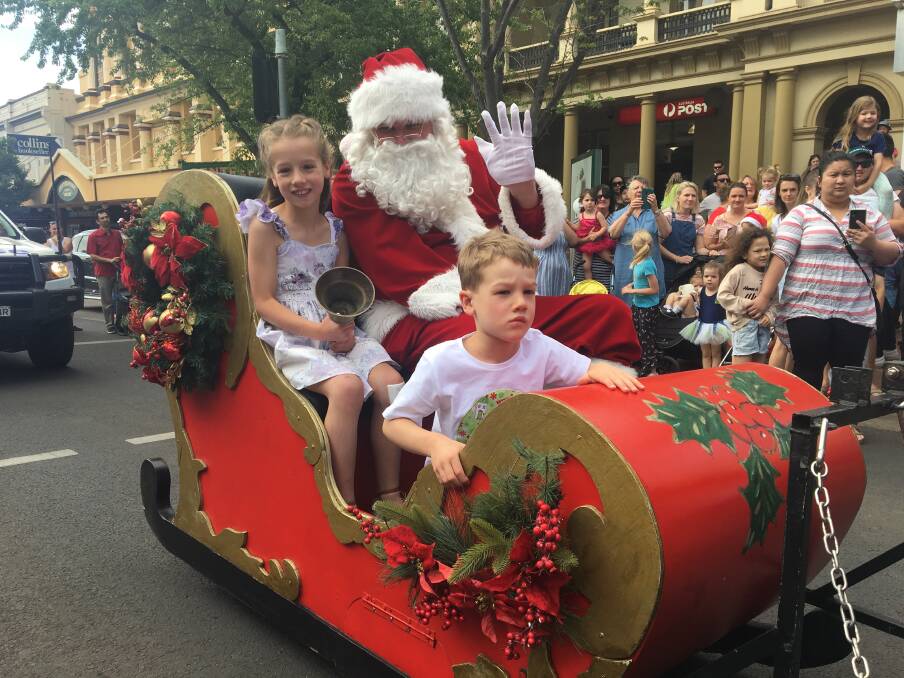 CHRISTMAS PARADE: Alannah and Owen Chisholm rode first-class into town with Santa on Saturday. Photo: ALEX CROWE