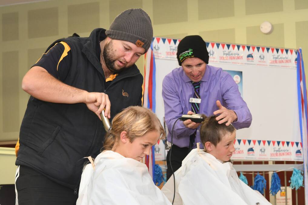 HEAD SHAVE: Drew Bale shaves Daniel Ritchie's head while Orange Public School principal Brad Tom takes to Thomas O'Brien with the clippers. Photo: JUDE KEOGH.