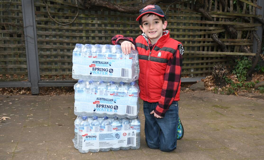 WATER RESCUE: Eight-year-old Murphy Sims was sad at what he saw on the news, so he decided to make some pocket money and do what he could to make things better. Photo: CARLA FREEDMAN 0723cfmurphysims4