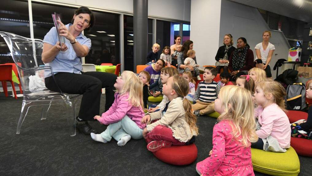 STORY TIME: Fiona Hawke, known to little library members as 'storytime lady', captures the imagination of her young audience. Photo: JUDE KEOGH 0523jkstory5