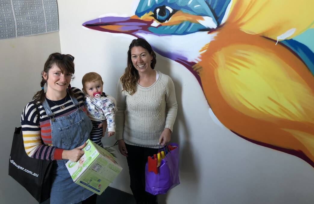 MUMS FOR MUMS: Anna Noonan, pictured with her 10-month-old baby Remi Allen, handed over a collection of baby supplies to House of Welcome caseworker Jessica Punch in Sydney on the weekend. Photo: CONTRIBUTED