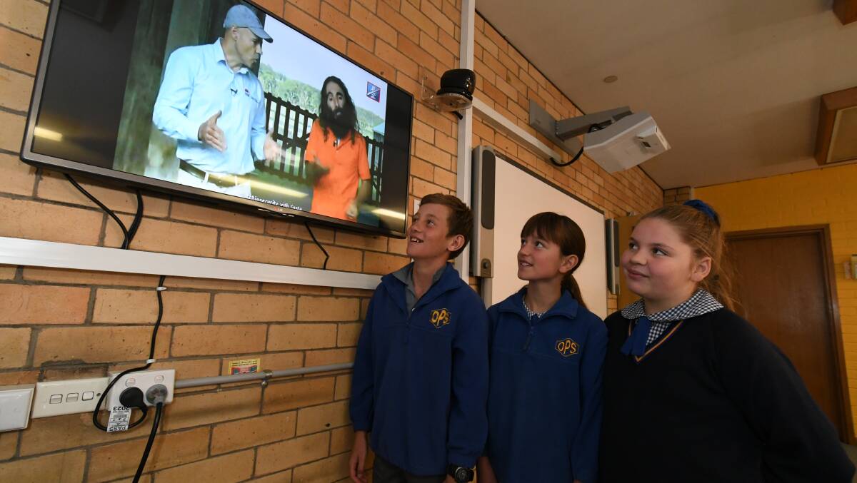 TV LESSONS: Orange Public School grade five student's Tom O'Brien, Eden Dickerson and Lara Campbell switch on to learn lessons on protecting our primary industries with Gardening Australia's Costa Georgiadis. Photo: JUDE KEOGH 0327jkcosta6