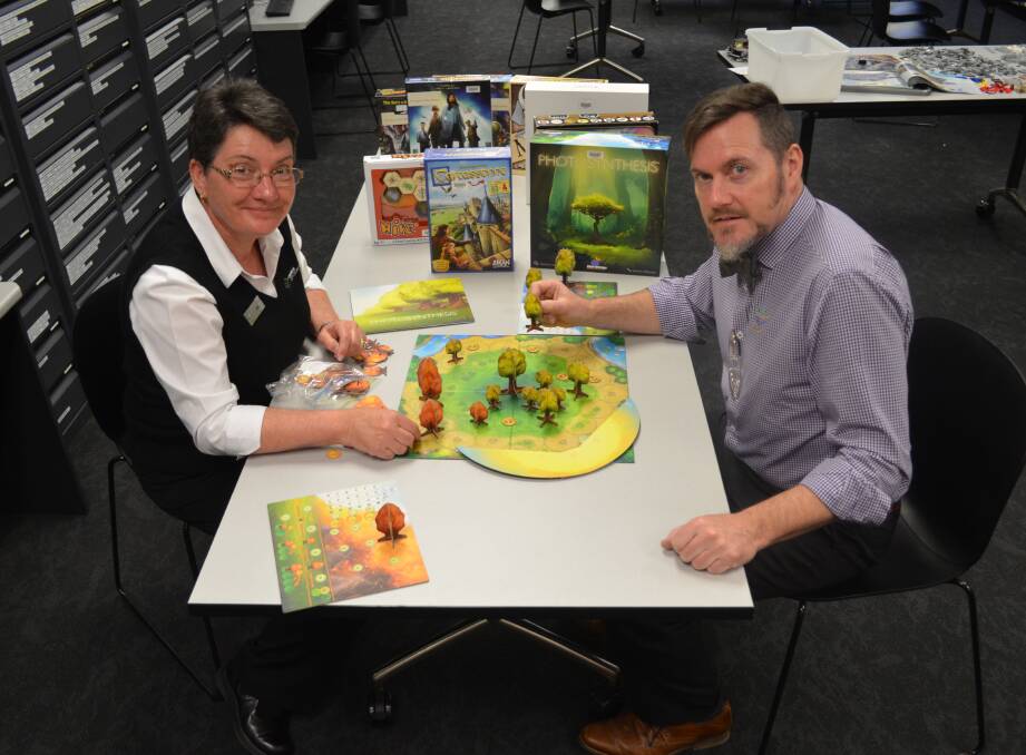 GAME DAY: Julie Sykes and Sean Brady show off some of the libraries huge selection of board games ahead of the school holiday activity. Photo: ALEX CROWE 0210acgames2
