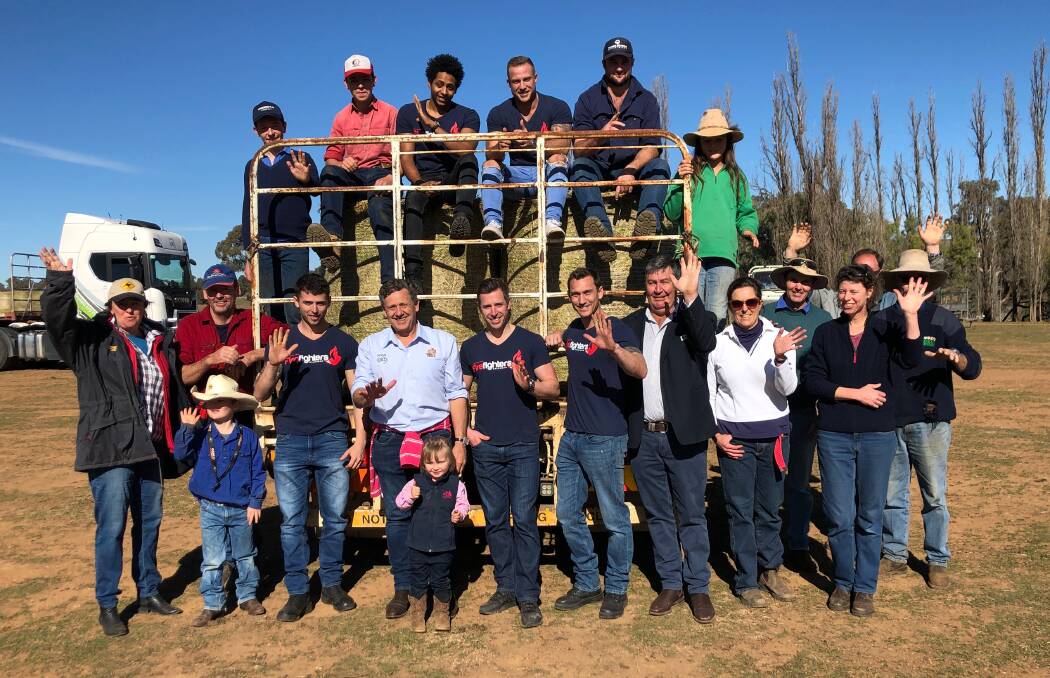HAY DAY: The Australian Firefighters Calendar guys with some of the Cumnock region farmers who received their donation of hay. Photo: SUPPLIED