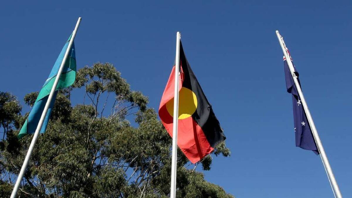 
A Torres Strait Islander flag, Aboriginal flag and Australian flag hang side-by-side as the debate about the Aboriginal Voice to Parliament still hangs in the air. 