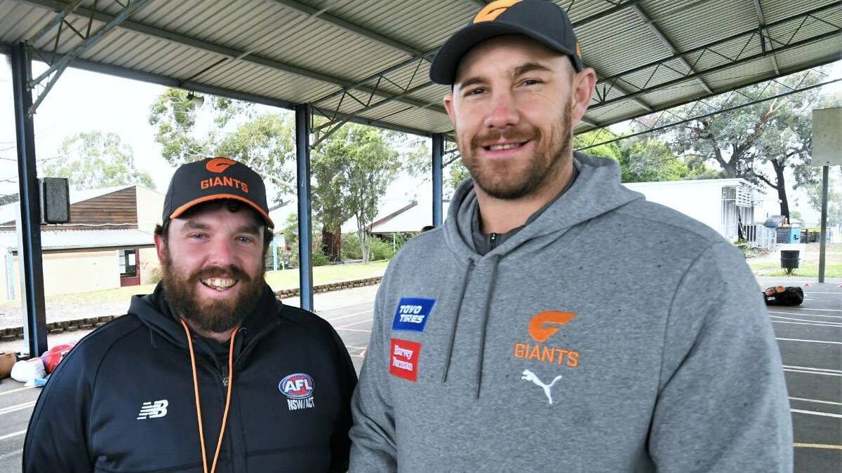 SCHOOL VISIT: Central West AFL competition and development coordinator Casey White, with GWS Giants ruck coach Shane Mumford at Bathurst West Public School. Photo: CHRIS SEABROOK