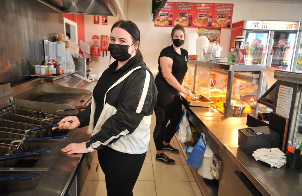 STILL OPEN: Peisley Street Flame Grilled Chicken employees Caitlin Brown and Natasha Ambachtsheer. The eatery is one of many in Orange which is still open and doing takeaway during lockdown. PHOTO: JUDE KEOGH 