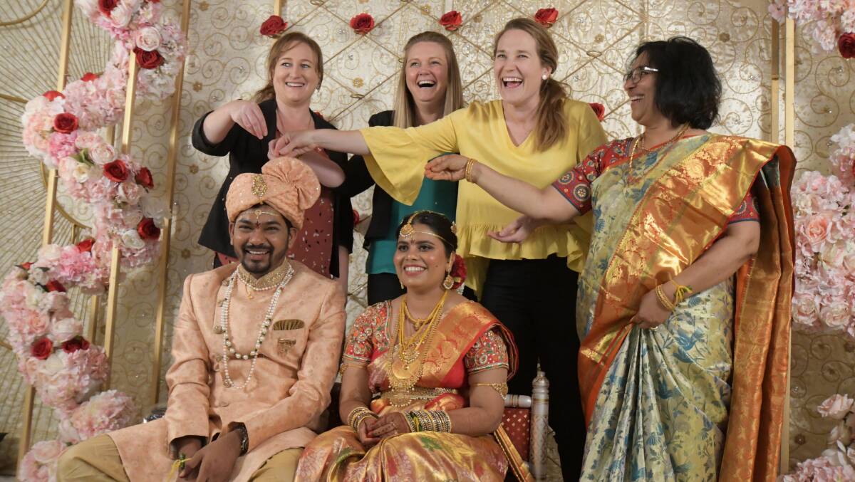 Wedding guests Veronica Kelly, Jolene Pearson and Michelle Murphy, along with mother-of-the-bride, Anantha Maddirala, pour rice onto the heads of bride, Sri Ramya, and groom, Krishna Teja. PHOTO: JUDE KEOGH 