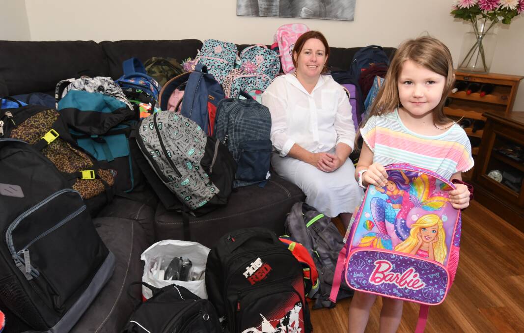IN THE BAG: Tracey Burfood and daughter Izzy, 6, with some of the 50-odd backpacks which were donated to her back-to-school drive by community members. PHOTO: JUDE KEOGH