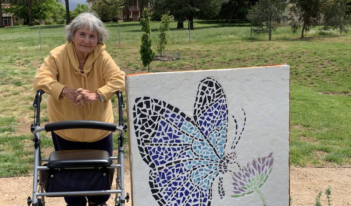 HAPPY PLACE: Benjamin Short Grove resident Helen Newton with one of the pieces of art in the award-winning community garden. PHOTO: SUPPLIED 