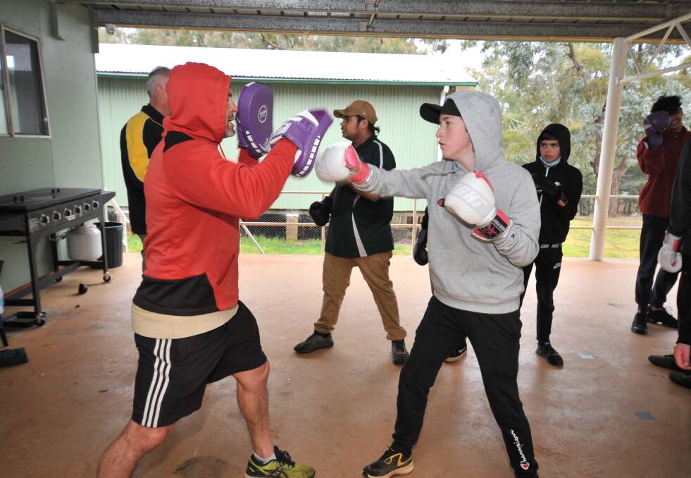 Teacher Scott Sullivan puts Jayden Kemp and the other boys through some boxing drills. 