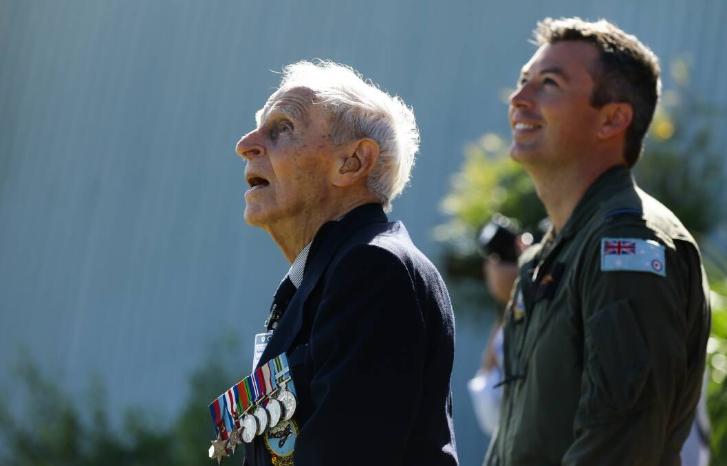 IN AWE: World War II pilot Sid Handsaker and current RAAF pilot Flying Officer James Bailey watch the Spitfire performing manoeuvres. 
