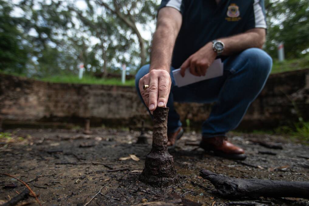 Scott Munro inspects one of the bolts that once held down an anti-aircraft gun. Picture: Marina Neil