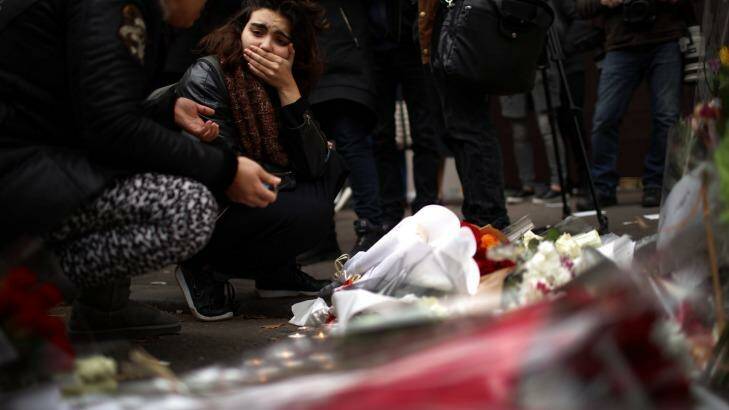 SHOCK: A woman places flowers near the scene of the Bataclan Theatre terrorist attack. Photo: FILE
