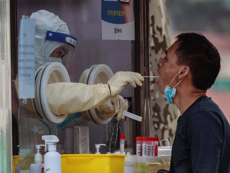 A man undergoes a coronavirus test at a makeshift testing booth in Shanghai, China. (EPA PHOTO)