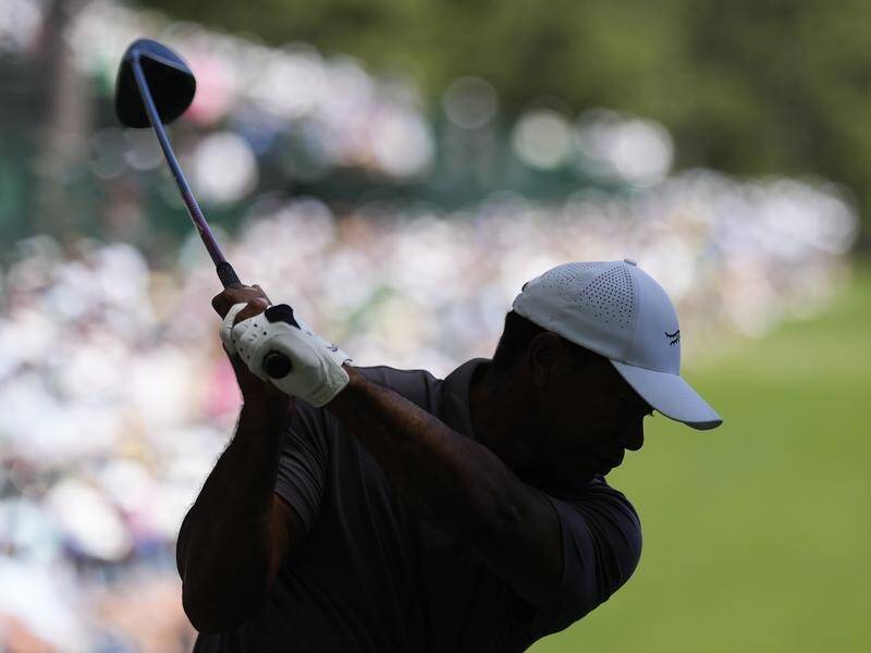Tiger Woods tees off at the 14th en route to making a record 24th straight cut at the Masters. (AP PHOTO)