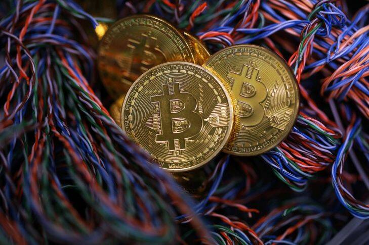 FILE: Bitcoins sit among twisted copper wiring inside a communications room at an office in this arranged photograph in London, U.K., on Tuesday, Sept. 5, 2017. Bitcoin is showing no signs of slowing down, the price of the largest cryptocurrency by market value is soaring as it gains greater mainstream attention despite warnings of a bubble in what not everyone agrees is an asset. Our editors select the best archive images on Bitcoin. Photographer: Chris Ratcliffe/Bloomberg