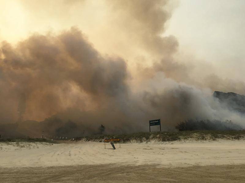 A massive water bombing operation has resulted in bushfires on Fraser Island being downgraded.