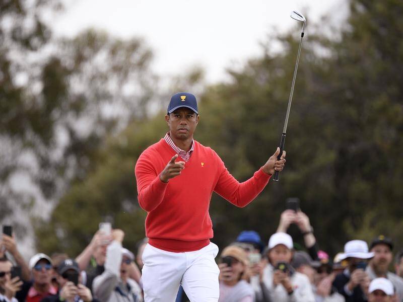 Tiger Woods has given the United States the first point in the Presidents Cup at Royal Melbourne.