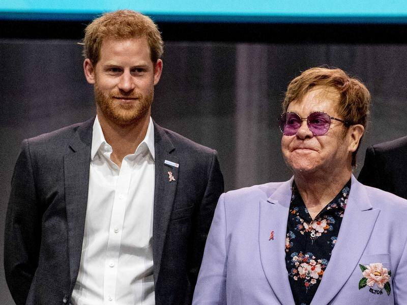 Elton John, pictured with Prince Harry, says men must be part of the Aids solution.