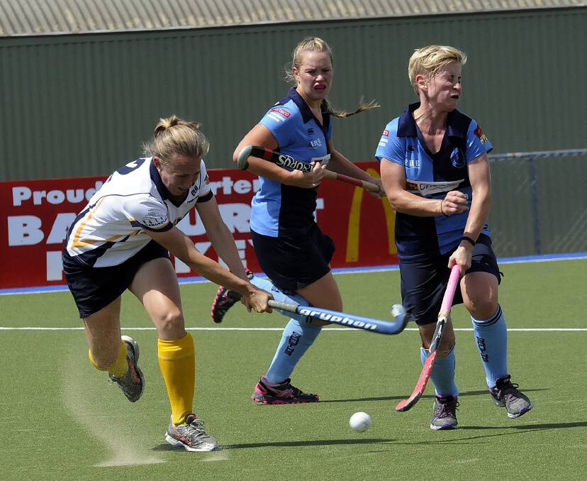 STICK IT: Kinross-CYMS’ Claire Goodall takes a swing as Souths’ Ash Corby (right) braces herself.  Photo: PHILL MURRAY 031514psouths3