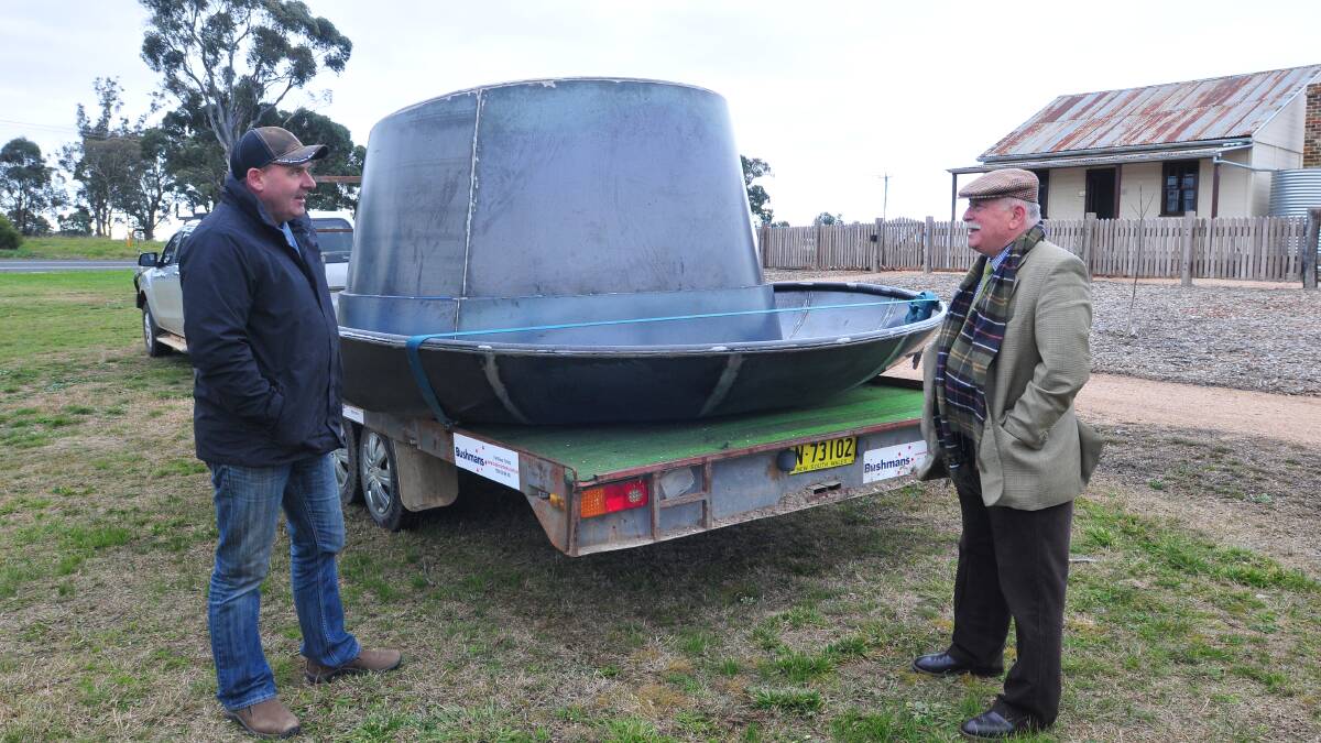 HOMELESS: Cr Chris Gryllis (right), assisted by transporter Steve Dale, helps with the giant Akubra Cr Gryllis had commissioned and was used in a documentary at the weekend. Photo: JUDE KEOGH  0628hat1