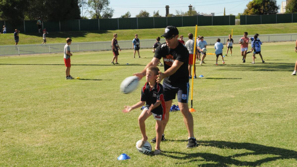 CHARITY CASE: Former NRL star Brad Fittler leads a skills clinic at Wade Park on Wednesday to raise money for Youth Off The Streets. Photo: MARK LOGAN 0304mlleague3