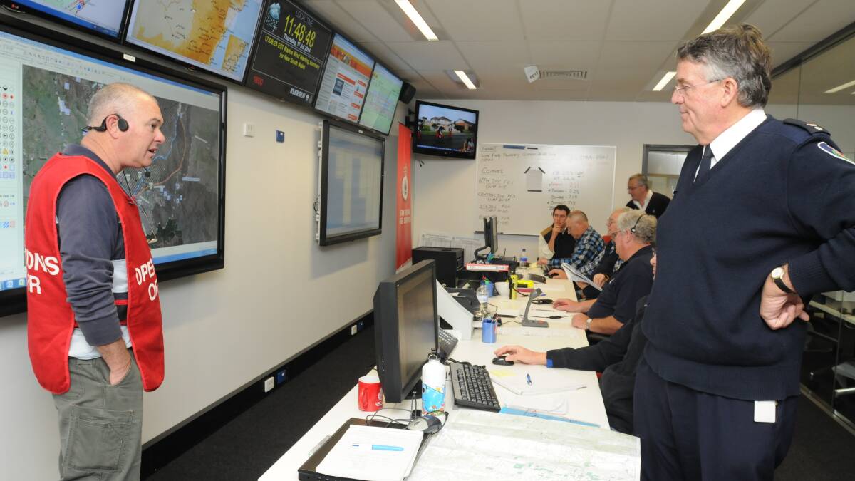 WORTHWHILE EXERCISE: Canobolas Zone NSW Rural Fire Service operations officer Bob Conran (left) and manager David Hoadley oversee the incident management exercise in front of the new state-of-the-art televisions. Photo: STEVE GOSCH 0717sgrfs1
