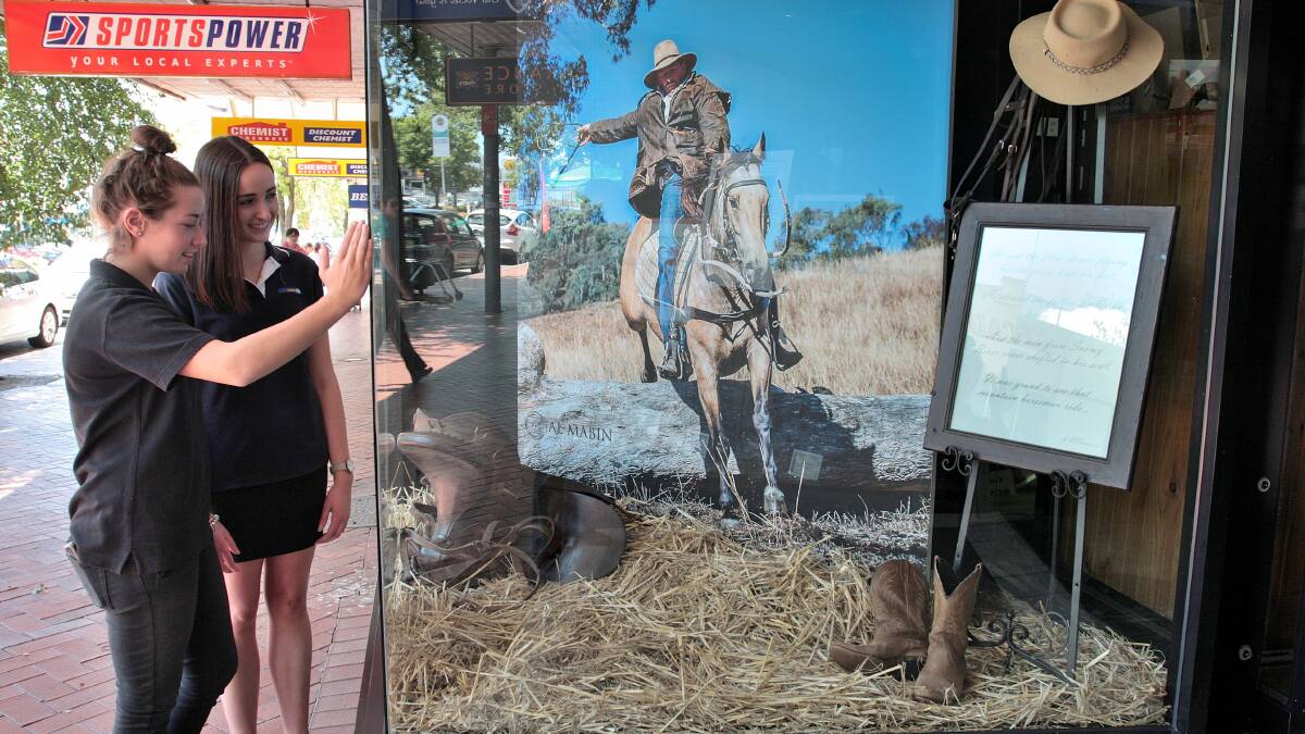 WINDOW SHOPPING: Orange Camera House staff Monique Pasquali and Caitlin Ahern check out their window display based on The Man from Snowy River for the annual Banjo Paterson festival. Photo: STEVE GOSCH  0212sgcamerahouse3
