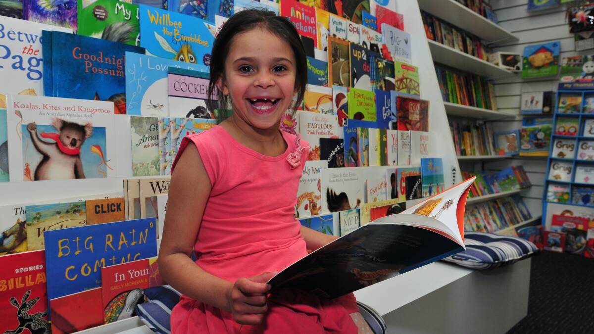 BOOK BOOM: Tahlarah Dixon, 6, reads one of the books that has accounted for a boom in children’s book sales in the last year. Photo: JUDE KEOGH 0812books3
