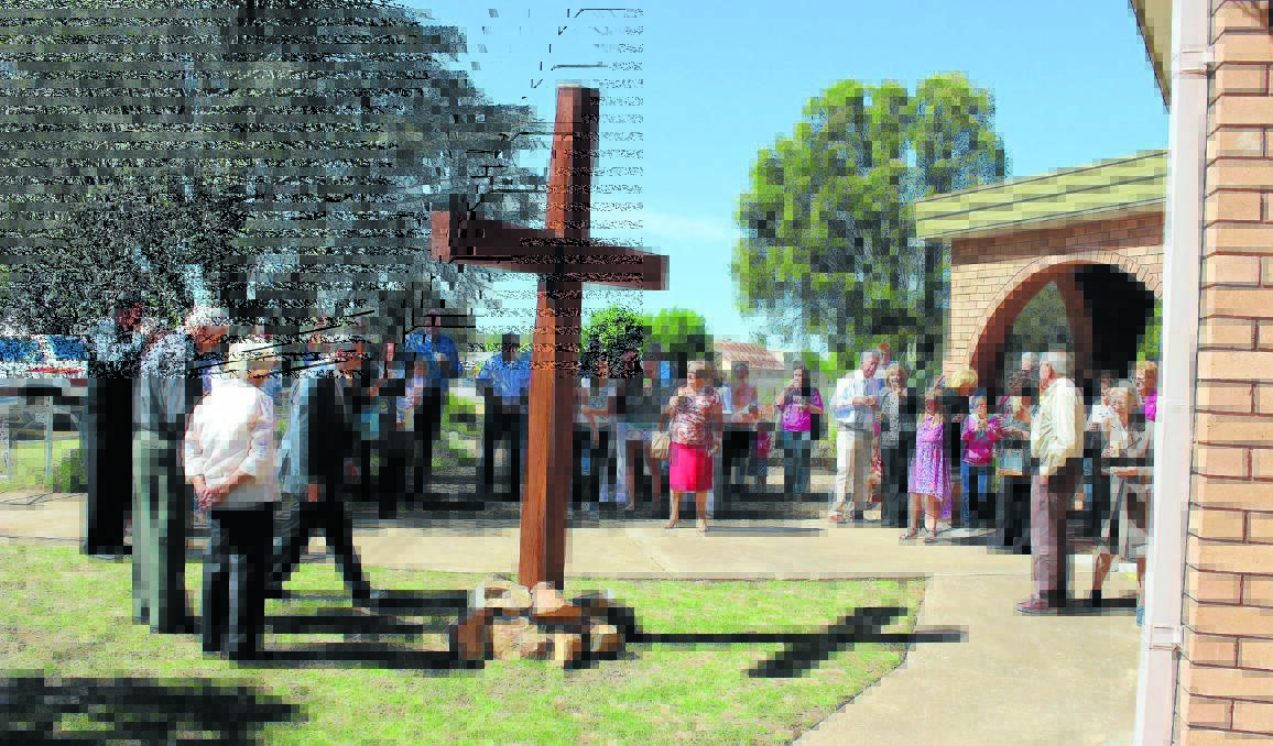 CHURCH ANNIVERSARY: Catholic Diocese of Bathurst Bishop Michael McKenna blesses a wooden cross made by congregation member Michael Antrobus at Yeoval’s Catholic Church of Our Lady.
