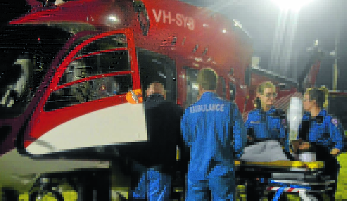TO THE RESCUE: Paramedics carefully deliver Wellington junior Peter Stewart into the medical retrieval helicopter.
