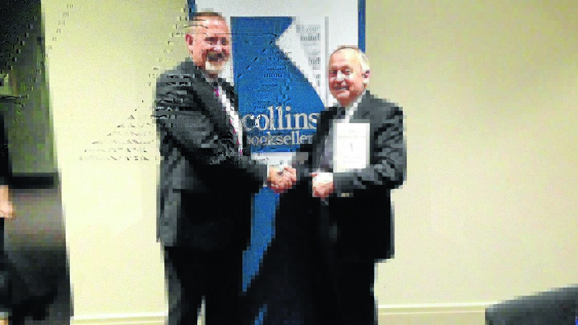 WINNING WAYS: Collins Booksellers chairman Duncan Johnson congratulates Phillip Schwebel on his marketing efforts. Photo: SUPPLIED