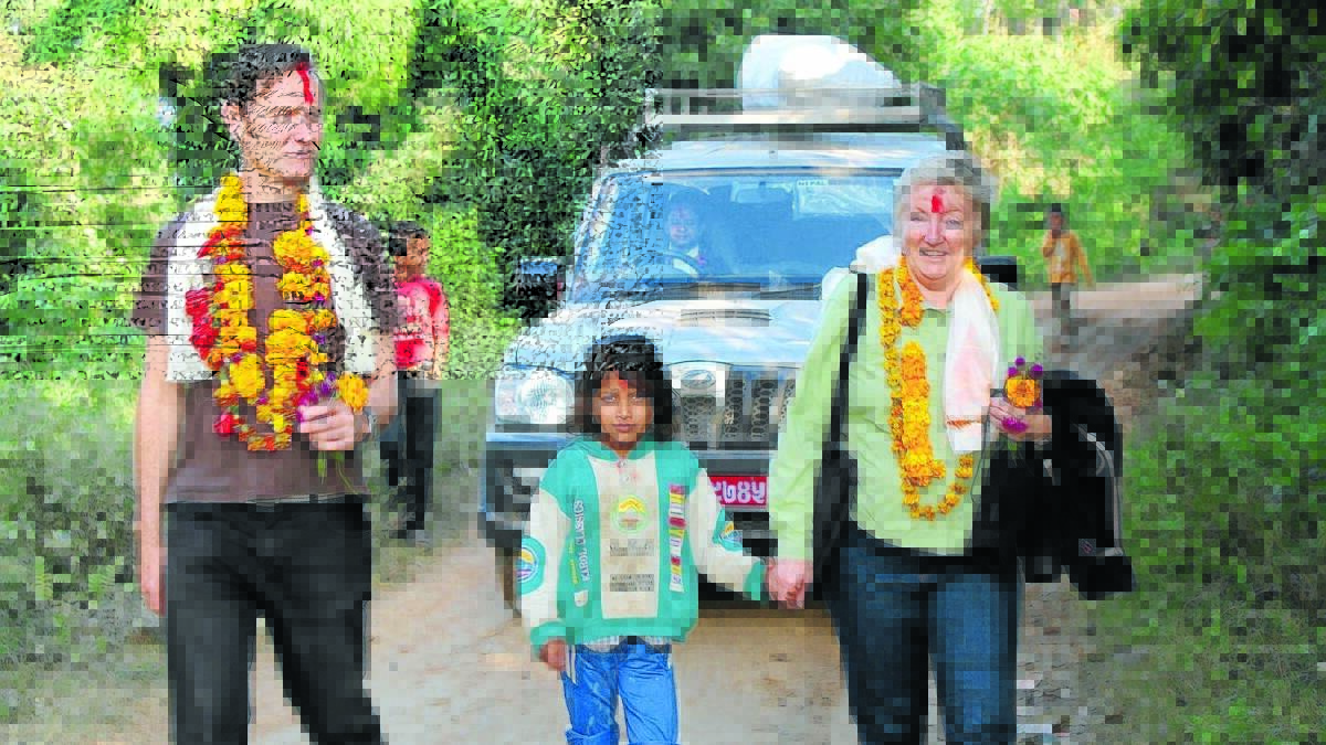 TRAUMA TEAM: Psychiatrist Dr Nick Burns and mental health manager Robyn Murray are returning to Nepal with a team of specialist mental health volunteers from Orange. They are pictured on their last trip with a young village girl. Photo: SUPPLIED