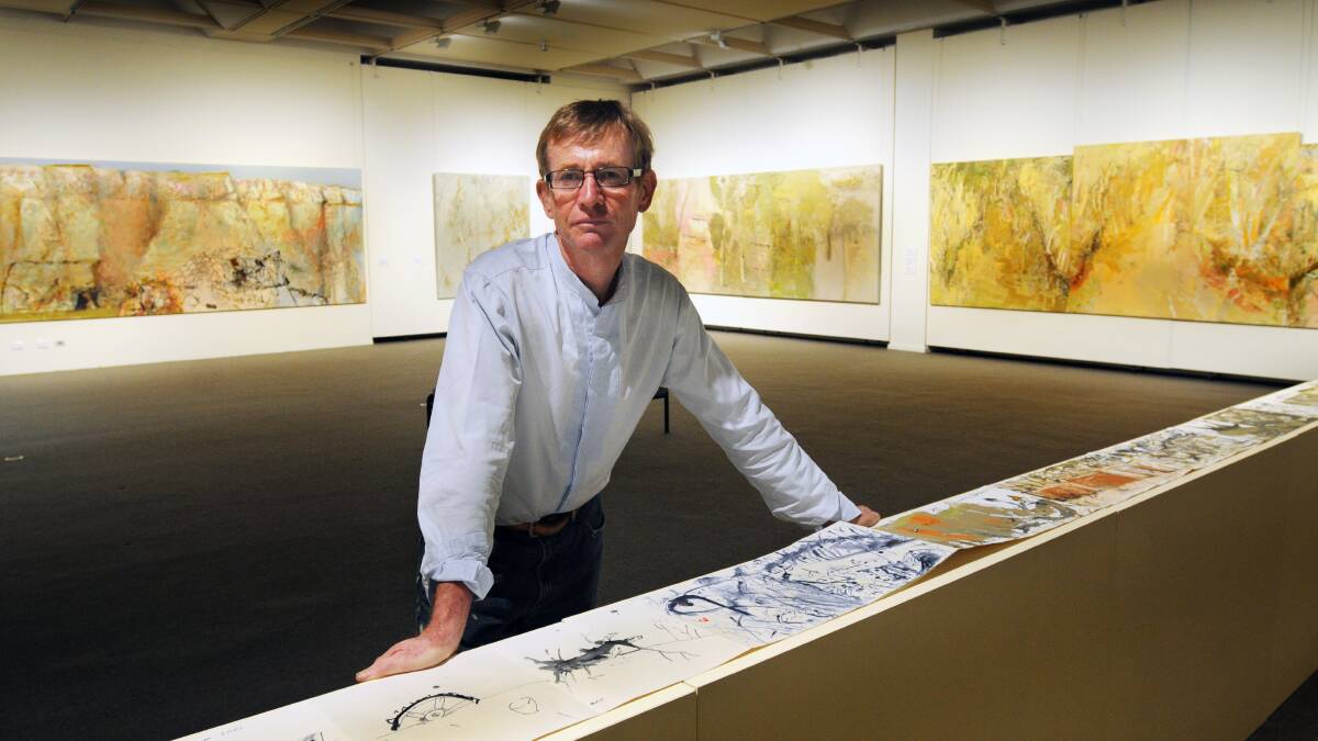 GRAND SCALE: John R Walker puts the finishing touches on his exhibition to open today at Orange Regional Gallery. 
Photo: STEVE GOSCH 0314sgart1
