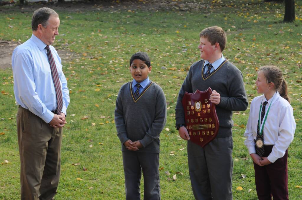 SPELLBOUND: Catherine McAuley Catholic Primary School principal Michael Croke takes Alan Parayil, champion speller Thomas Dews (with his trophy) and Lucy Stewart through their paces. Photo: STEVE GOSCH                                                                                                                  0602cathspell4
