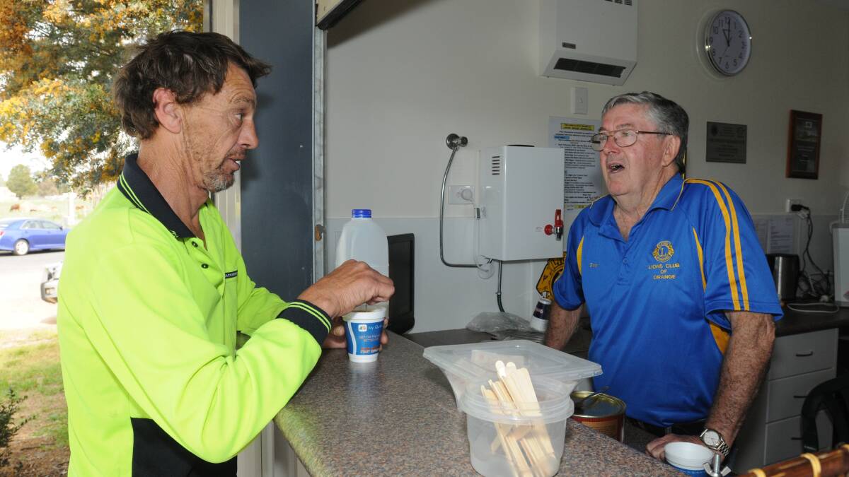 ON THE ROAD: Traveller Ross King chats to Lions Club of Orange member Errol McCann at the Orange Driver Reviver on Monday at the end of a busy long weekend. Photo: STEVE GOSCH 1005sgdriver1