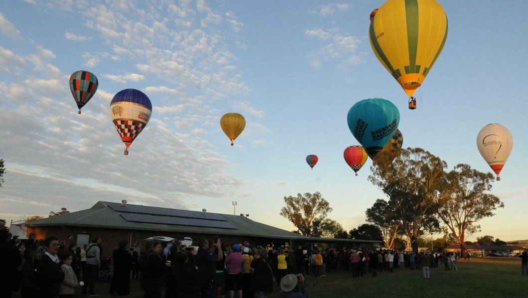 Just after 6.30am as dawn broke over Canowindra, hundreds of balloons were released in tribute as the hot air balloons fired up and simultaneously rose skyward. Photo: JUDE KEOGH