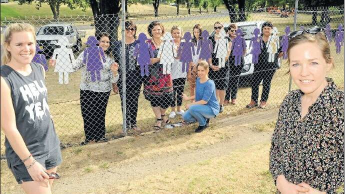 TAKING A STAND: Last year Family Violence Awareness Group vice chair Temeka Jones, member Yasmin Dowling and treasurer Annelie Watt joined other
members in erecting cut-outs at Carrington Park to mark White Ribbon Day. Photo: CHRIS SEABROOK 112415cwomen