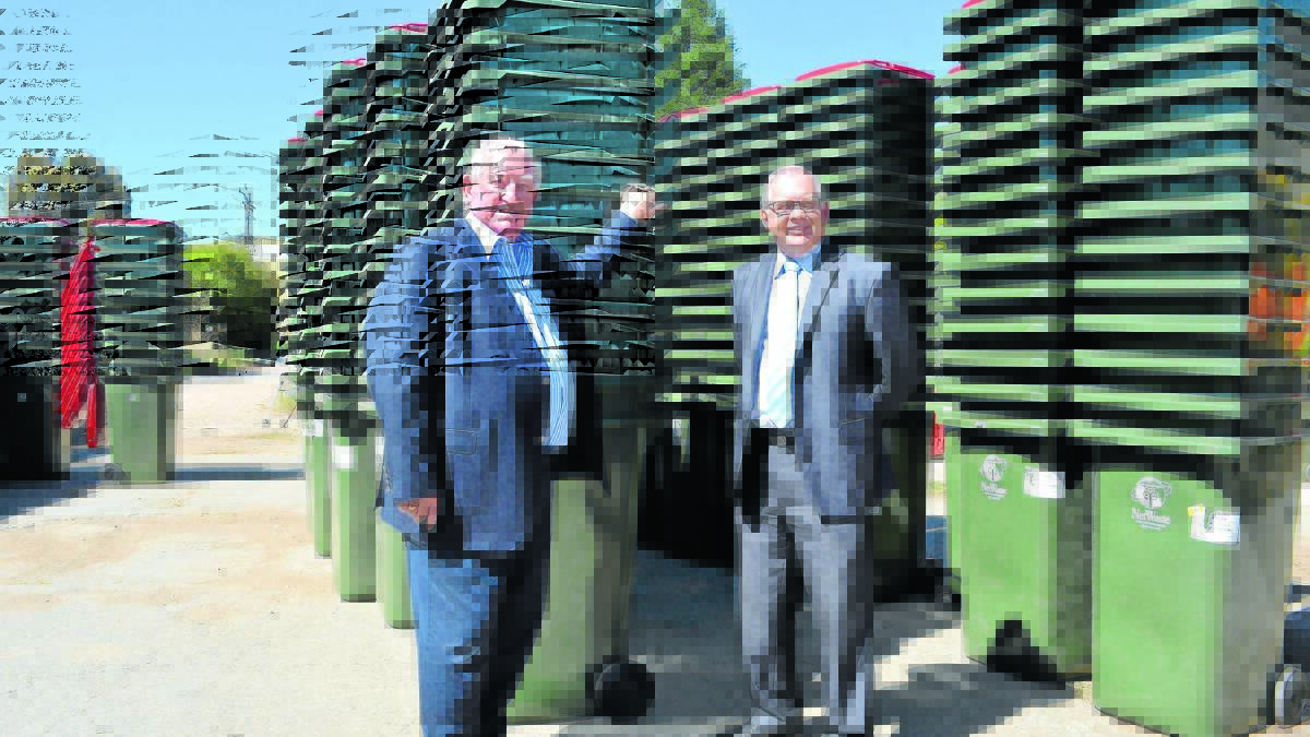 READY TO ROLL: Orange mayor John Davis and councillor Jeff Whitton with the 8000 bins to be distributed across Cabonne - another 45,000 will be delivered to Orange in time for the new waste contract in April. Photo: DANIELLE CETINSKI 												                