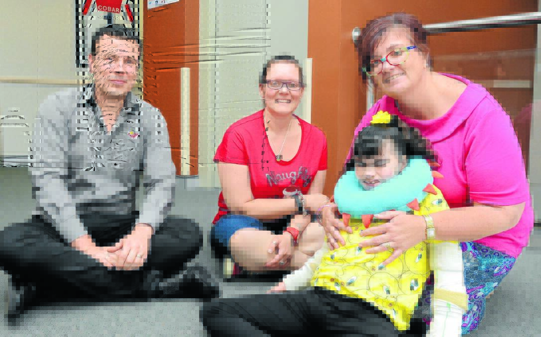 HELPING HANDS: Sandra Wicks (right) will be able to transport her daughter Kyah Lucas more easily thanks to a $20,000 donation from OAMS that was organised by business manager Michael Halls and admin officer Krystal Dennis. Photo: JUDE KEOGH 