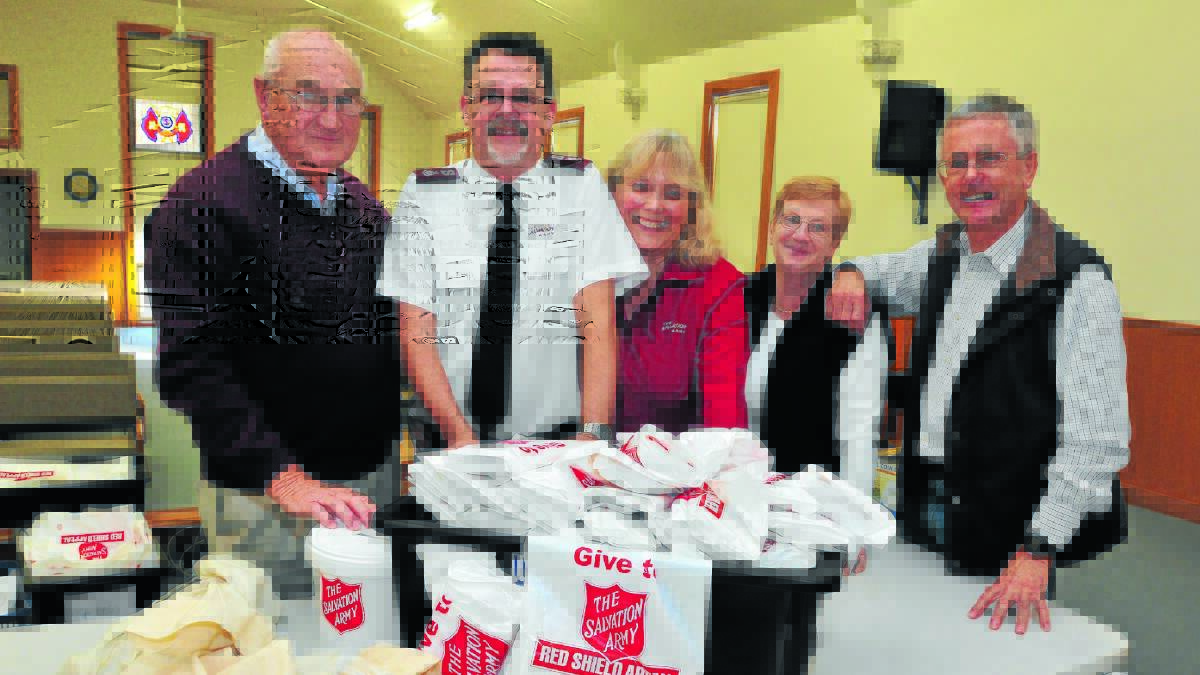 IN THE BAG: George Godkin, Major Greg Saunders, Major Karen Saunders with Carol and John Moss during the Red Shield Appeal count on Sunday. Photo: JUDE KEOGH 0525salvocount1