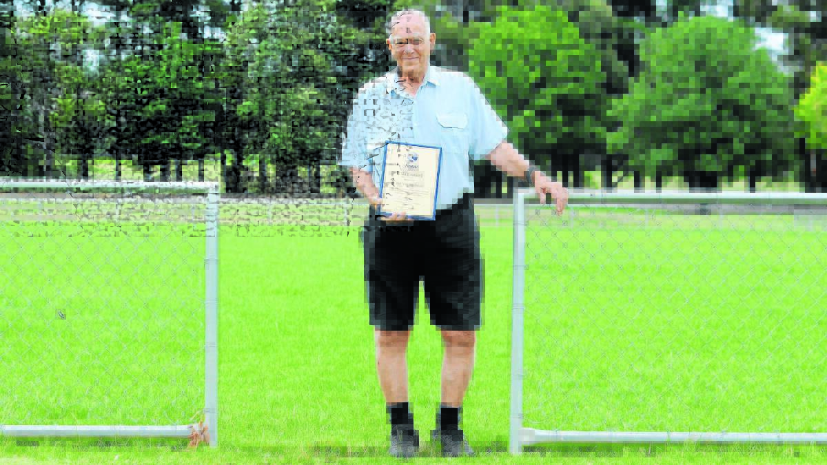DESERVING: Orange's Bernie Stedman shows off his Football NSW State Award at the field named after him. Photo: JUDE KEOGH 0105bernie5