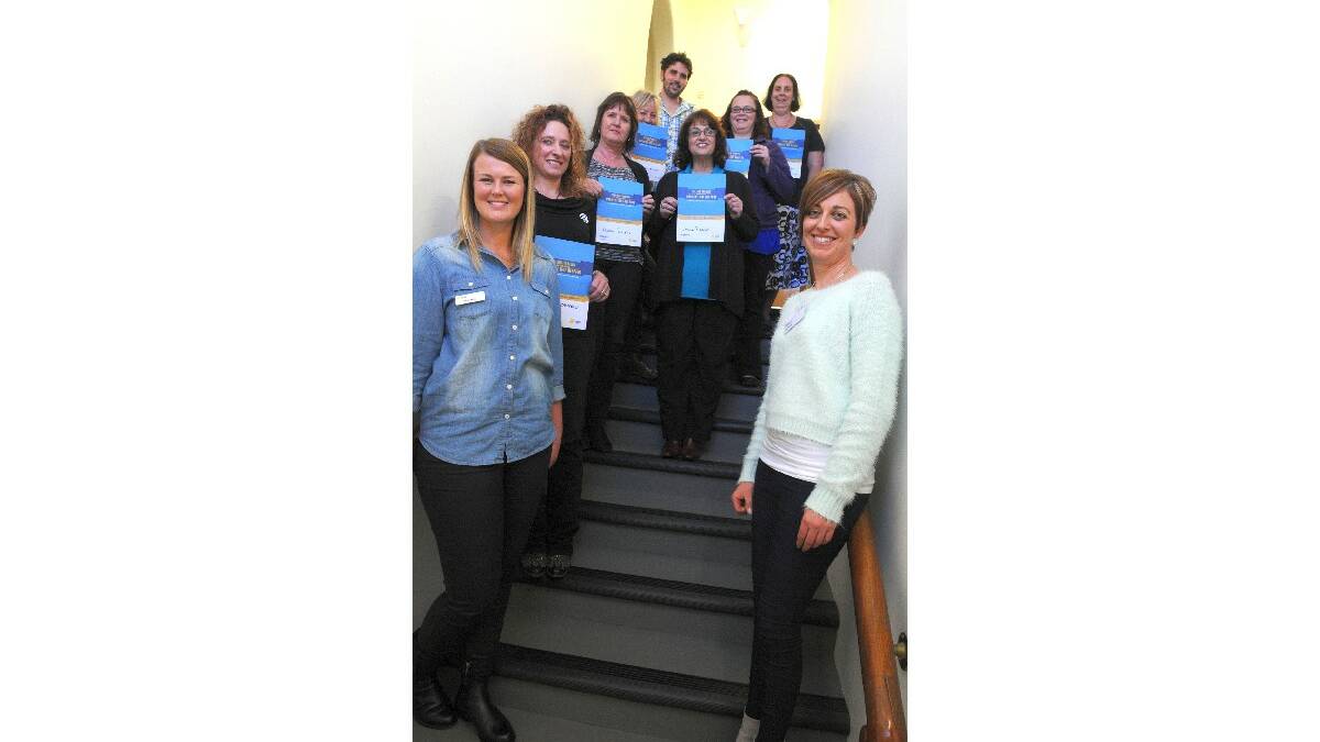 TAKING THE PLEDGE: Lyndon Community workers (clockwise from left) Michelle Campbell, Karina Falconer, Wendy Tynan, Josh Snowden, Donna Picker, Karen Wilson and Maree Keen hold their pledge certificates while Cancer Council representatives Bree Kelly (front left) and Fiona Markwick (front right) look on.  Photo: STEVE GOSCH                                                  0526pledge1
