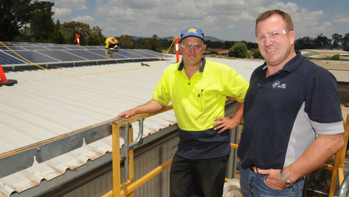 SOLAR POWER: ePho operations manager Luke Butterworth and PJL managing director Phil Wilkin view the installation of new solar panels. Photo: STEVE GOSCH. 1127sgsolar2. 

