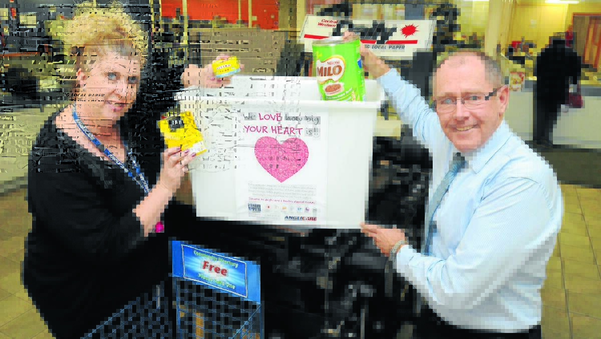 FORK OUT: Anglicare administration assistant Christie McGuirk and Central Western Daily managing editor Tony Rhead ask people to consider those less fortunate than themselves during Anglicare’s Pantry Appeal.
Photo: Steve Gosch