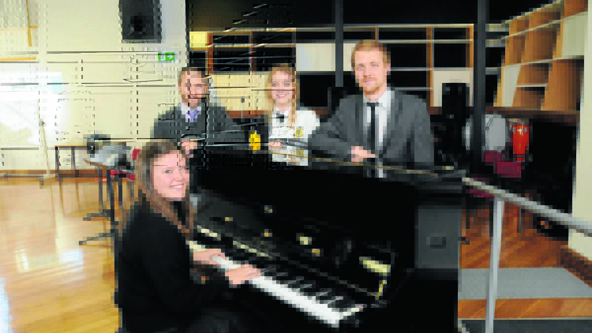 AIMING FOR A HIGH NOTE: Orange High School music teachers Brian Irvine and Seb Key with students Bella Fox (at back) and Beth Clarke who are enthusiastic about a fundraising to buy a grand piano for the school. Photo: STEVE GOSCH                                                              0501piano1