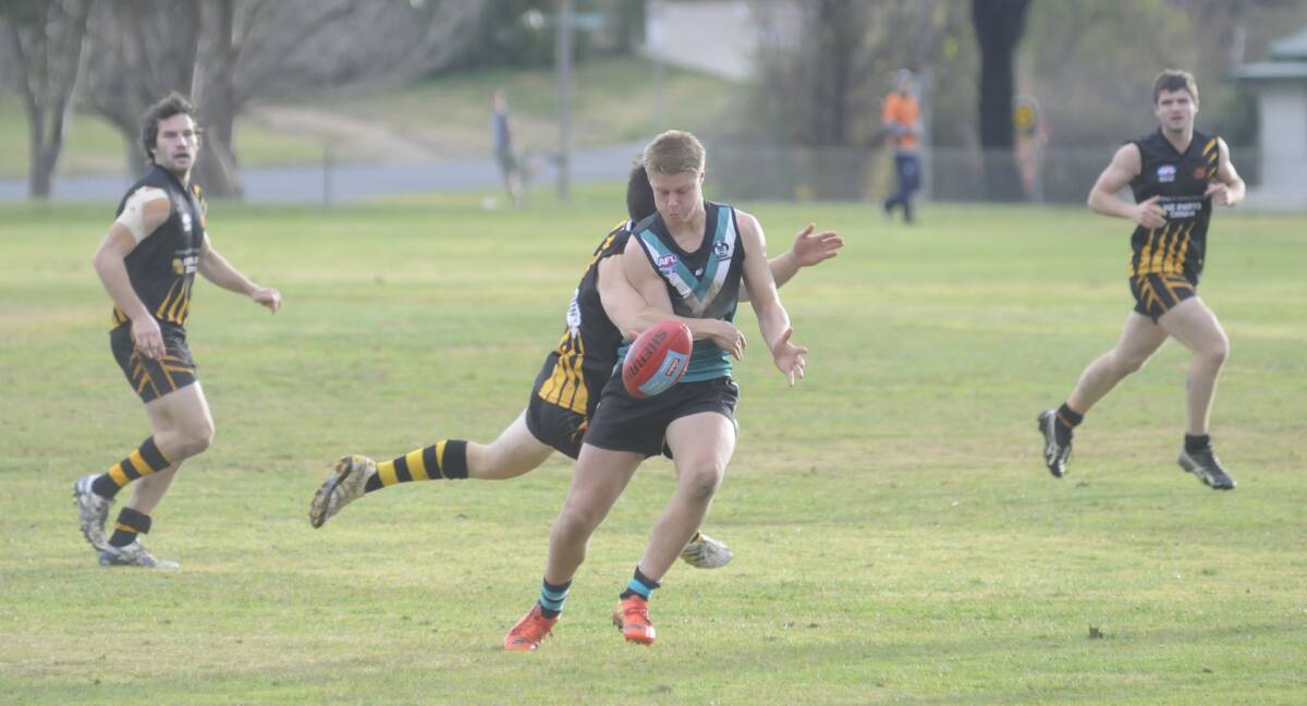 RUNNING GAME: Bathurst Bushrangers' Mike Waldren gets some attention from an Orange Tigers defender in their Central West AFL match. Photo: CHRIS SEABROOK