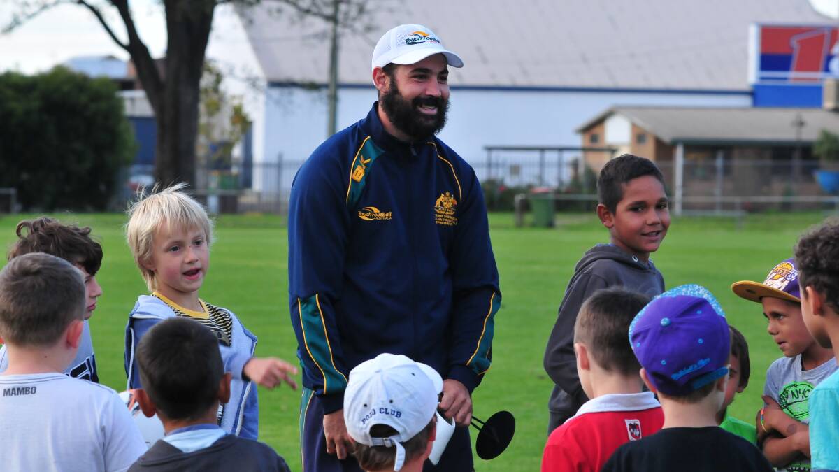 BUSHMAN: Australian mixed touch football team member Trent Touma chats to some children during a coaching clinic at Wade Park yesterday. Photo: JUDE KEOGH 0422touch15