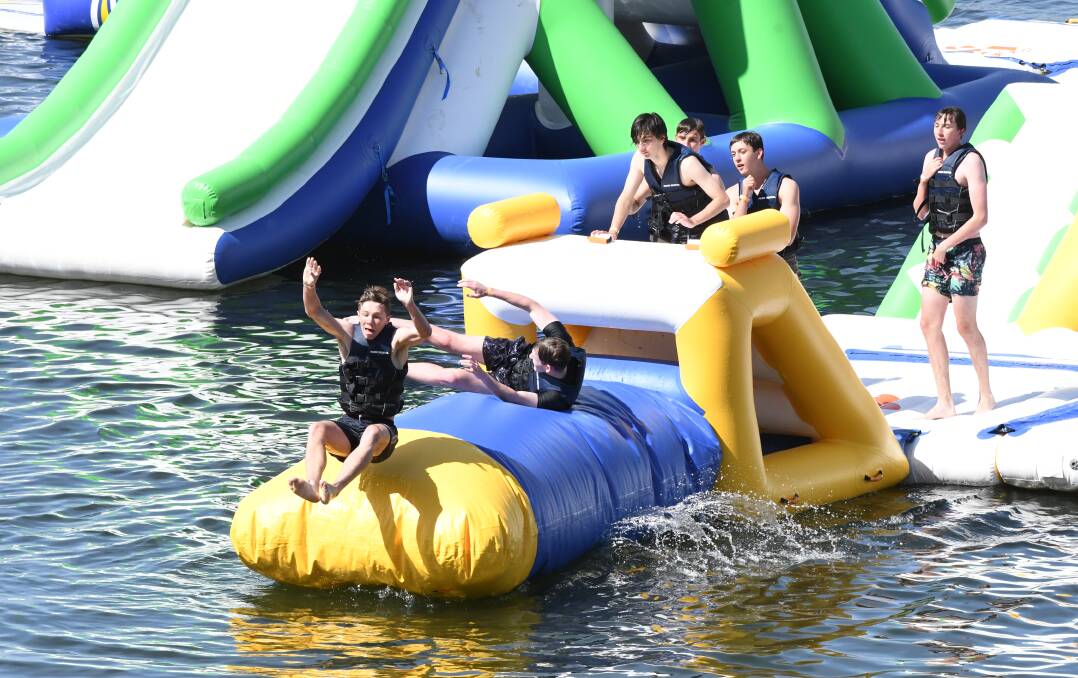 JUST GO FOR IT: Some satisfied customers having a great time testing out the new Aqua Park at Ben Chifley Dam on Sunday. Photo: CHRIS SEABROOK 110418caqua1a
